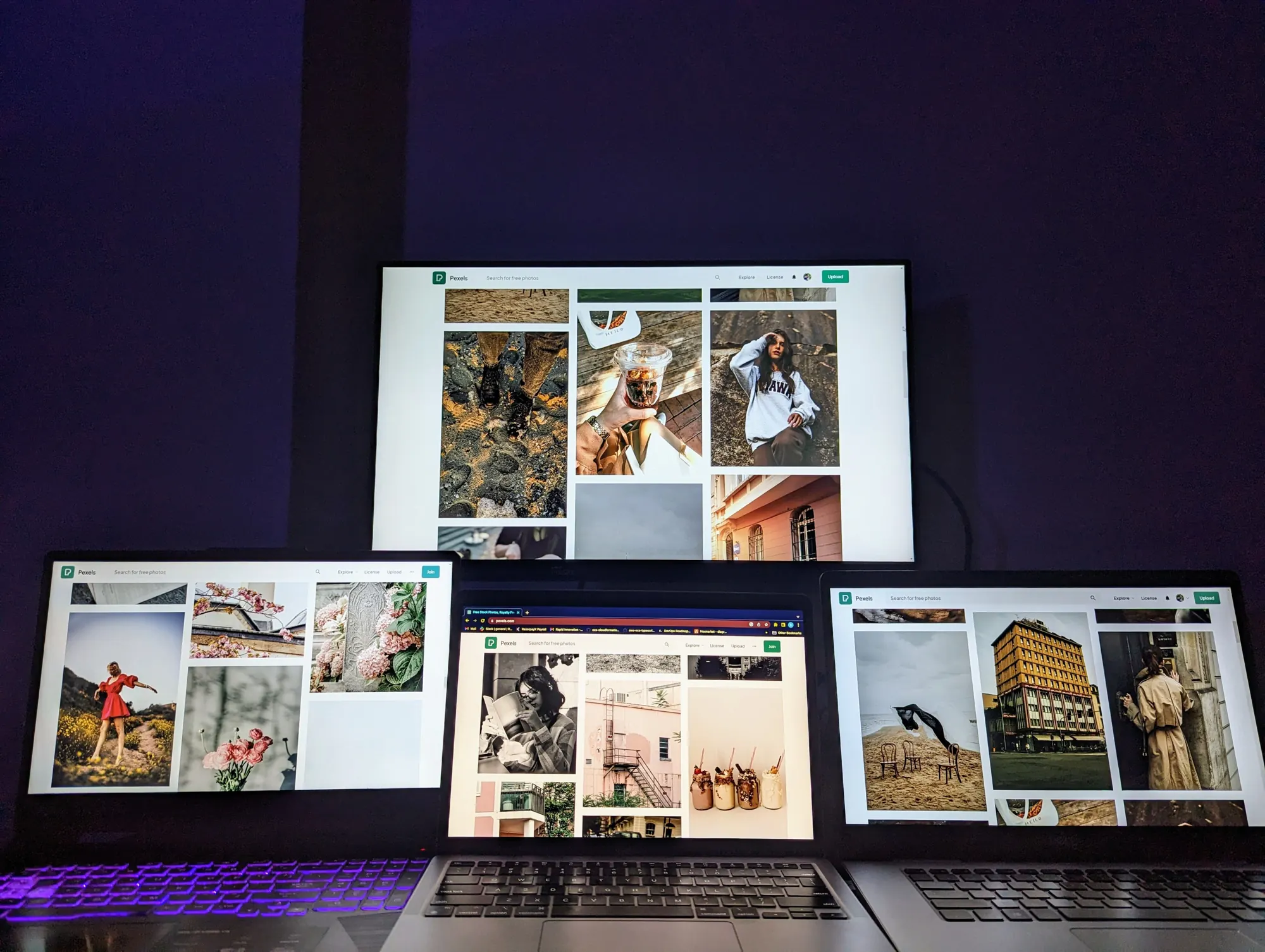 Several screens showing websites in a dark room