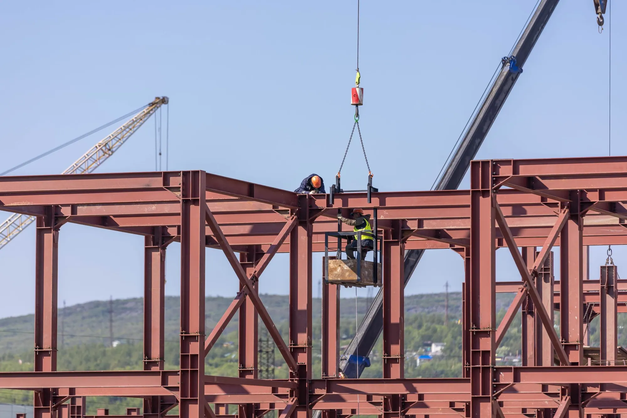 Steel roof trusses with a tower crane beyond
