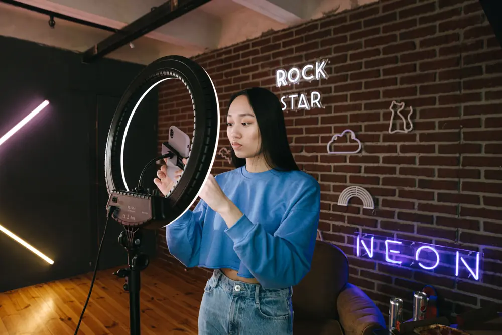 Creator filming with a phone and ring light