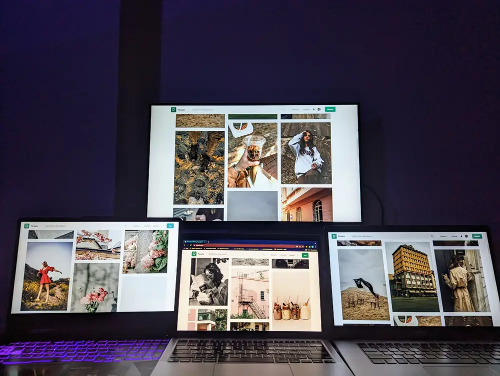 Several screens showing websites in a dark room